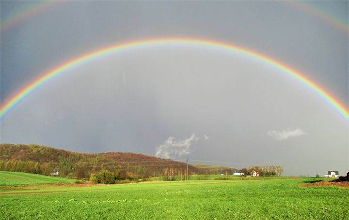Podwójna tęcza nad zielonymi łąkami w okolicach Harty